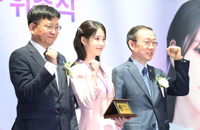 아이유(IU·본명 이지은)가 25일 인천국제공항 제1터미널에서 열린 인천공항본부세관 홍보대사 위촉식에서 위촉장과 위촉패를 받은 뒤 이명구(오른쪽) 관세청장과 김종호 인천공항본부세관장과 기념 촬영을 하고 있다. 영종도=오승현 기자 2025.07.25