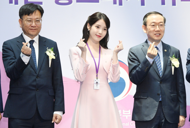 아이유(IU·본명 이지은)가 25일 인천국제공항 제1터미널에서 열린 인천공항본부세관 홍보대사 위촉식에서 위촉장과 위촉패를 받은 뒤 이명구(오른쪽) 관세청장과 김종호 인천공항본부세관장을 비롯한 세관 관계자들과 기념 촬영을 하고 있다. 영종도=오승현 기자 2025.07.25
