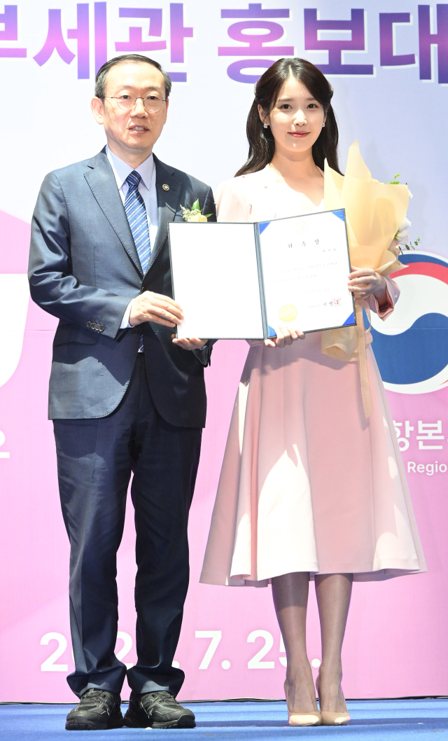 아이유(IU·본명 이지은)가 25일 인천국제공항 제1터미널에서 열린 인천공항본부세관 홍보대사 위촉식에서 이명구 관세청장에게 위촉장을 받은 뒤 기념 촬영을 하고 있다. 영종도=오승현 기자 2025.07.25