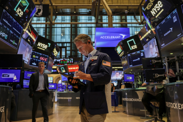 25일(현지 시간) 미국 뉴욕증권거래소(NYSE)에서 한 거래중개인이 주식 화면을 들여다보고 있다. 로이터연합뉴스