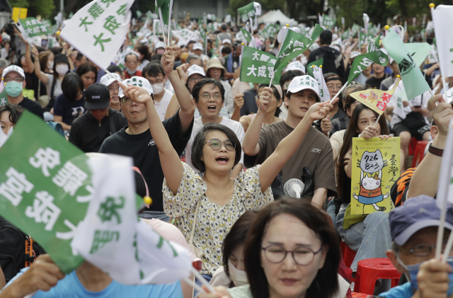 대만 타이베이에서 26일 야당인 국민당 소속 의원 24명을 파면할지 여부를 결정하는 선거에서 결과가 나오자 시민들이 반응하고 있다. AP연합뉴스