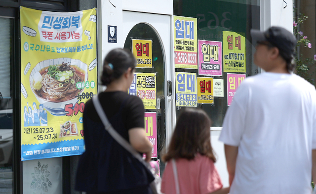 27일 경북 경산시 한 상가에 민생회복 쿠폰 사용처라는 안내 현수막이 붙어 있는 가운데 옆 상가는 폐점한 채 임대 안내문이 붙어있다. 연합뉴스