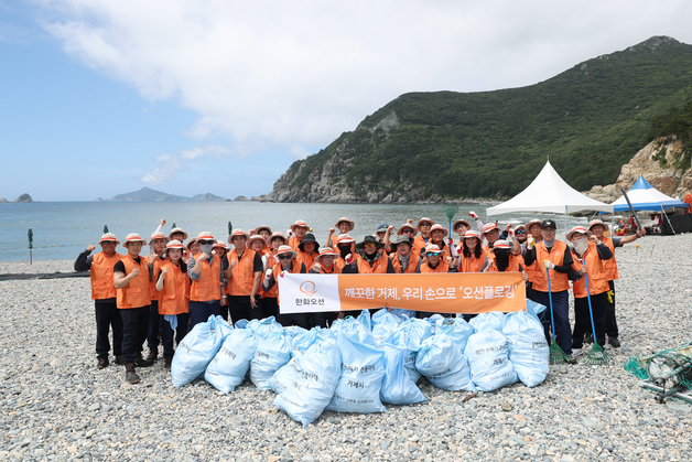 한화오션 임직원들이 21일 거제 여차해수욕장에서 해양 쓰레기 수거 활동을 마친 후 기념 촬영을 하고 있다. 사진 제공=한화오션