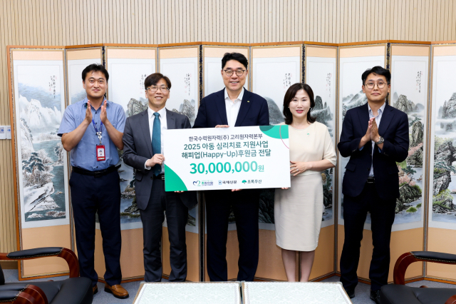 이상욱(가운데) 고리원자력본부장이 이수경(왼쪽 네 번째) 초록우산 어린이재단 부산지역본부장에게 아동 심리치료 후원금을 전달하고 기념 촬영을 하고 있다. 사진제공=고리원자력본부