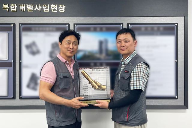롯데건설 관계자들이 '안전 릴레이' 캠페인을 진행을 위한 바통을 전달하고 기념촬영을 하고 있다. 사진 제공=롯데건설