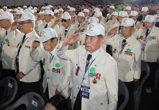 27일 경기도 고양시 킨텍스에서 열린 유엔군 참전의 날 기념식에서 6·25 참전유공자들이 국기에 경례하고 있다. 연합뉴스