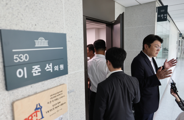 김정철 개혁신당 최고위원이 30일 서울 여의도 국회 의원회관 이준석 의원실 앞에서 '김건희특검 관련 압수수색 절차적 문제점 및 준항고 주요 이유 언론 브리핑'을 하고 있는 가운데 특검 관계자들이 압수수색을 위해 의원실로 들어가고 있다. 연합뉴스