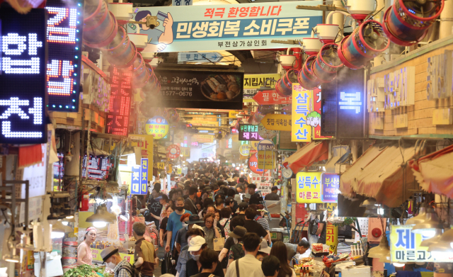 중복인 지난 달 30일 찜통 폭염이 이어지는 가운데 부산 부산진구 부전시장에 상인회에서 내건 '민생회복 소비쿠폰 환영' 펼침막과 쿨링 포그가 방문객들을 맞이하고 있다. 연합뉴스