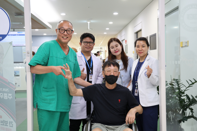 창원한마음병원 장기이식센터 의료진들이 간이식 수술 후 회복 환자와 기념 사진을 촬영하고 있다. 사진 제공=창원한마음병원