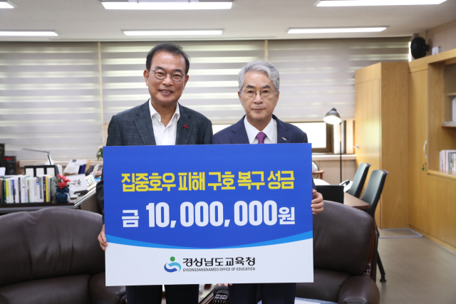 박종훈(오른쪽) 경남도교육감이 4일 강기철 경남사회복지공동모금회장에게 집중호우 피해 구호 성금 1000만 원을 전달하고 있다. 사진 제공=경남도교육청