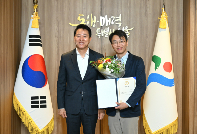 오세훈 서울시장이 1일 서울 중구 서울시청에서 '서울 건강총괄관'에 위촉된 정희원 박사와 기념 촬영하고 있다. 서울시 제공