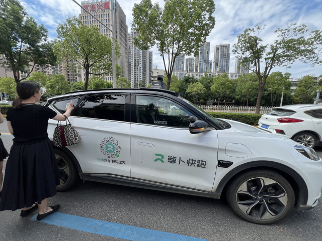 한 이용자가 2024년 8월 2일 중국 우한에서 운행중인 무인 자율주행 로보택시 서비스 ‘뤄보콰이파오’(아폴로 고)에 탑승하기 위해 자신의 휴대전화 번호를 입력하고 있다. 김광수특파원.