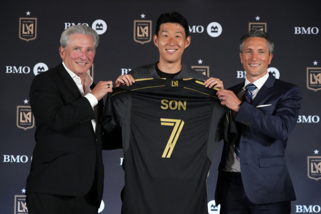 손흥민(가운데)이 7일 미국 LA BMO 스타디움에서 열린 LA FC 입단 기자회견에서 등번호 7번 유니폼을 들고 포즈를 취하고 있다. 왼쪽은 베넷 로즌솔 공동 구단주, 오른쪽은 존 소링턴 단장이다. 이매진이미지스연합뉴스