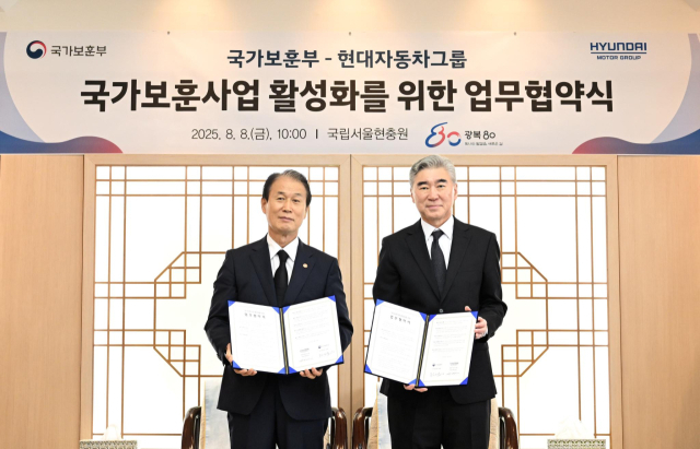 권오을(왼쪽) 국가보훈부 장관과 성 김 현대차그룹 전략기획담당 사장이 8일 국립서울현충원에서 국가 보훈 사업 활성화를 위한 업무협약을 체결한 뒤 협약서를 들어보이고 있다. 사진 제공=현대차그룹