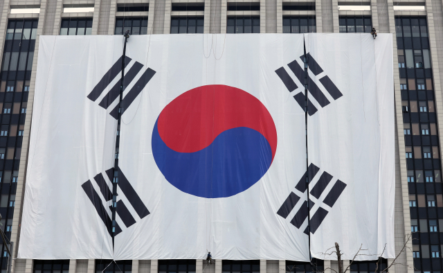 광복 80주년을 나흘 앞둔 11일 오전 서울 종로구 정부서울청사 외벽에 대형 태극기가 설치되고 있다. 뉴스1