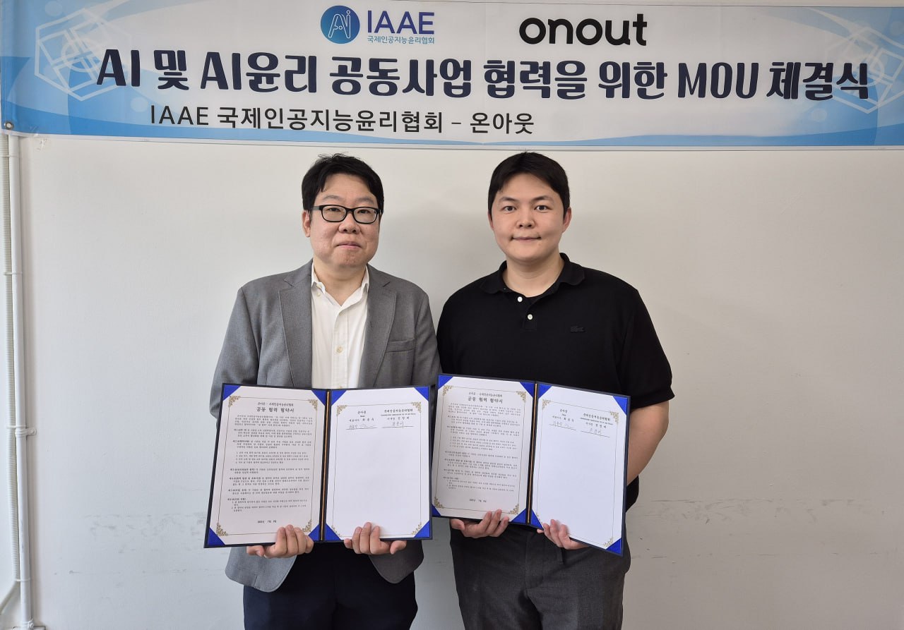 ▶국제인공지능윤리협회 전창배 이사장(좌측)과 온아웃 최용우 대표가 업무협약을 체결하고 기념 촬영하고 있다. (사진=IAAE)