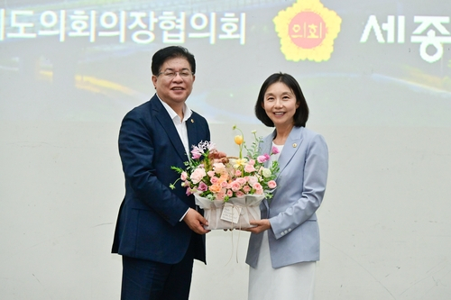 최호정(오른쪽) 서울시의회 의장이 제19대 대한민국시도의회의장협의회장에 선출된 후 축하 꽃바구니를 전달받고 있다. 사진 제공=서울시의회