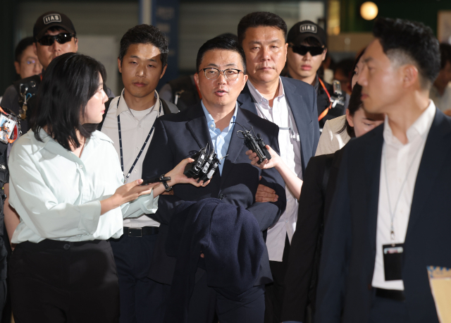 김건희 여사 일가의 '집사'로 지목된 김예성씨가 12일 인천국제공항 제1여객터미널을 통해 입국한 뒤 민중기 특별검사팀에 체포돼 이동하고 있다.영종도=연합뉴스