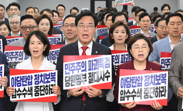 송언석 비상대책위원장 겸 원내대표를 비롯한 국민의힘 의원들이 14일 서울 여의도 중앙당사에서 열린 의원총회에서 특검의 압수수색 중단을 촉구하며 피켓 시위를 하고 있다. 오승현 기자