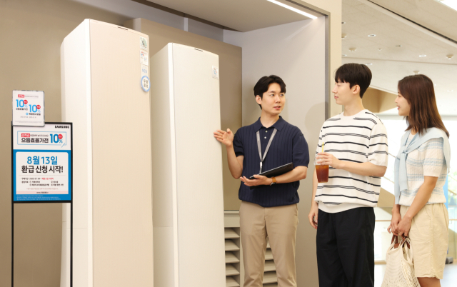 삼성전자 모델이 에너지 소비효율 1등급의 세탁건조기와 에어컨 제품의 설명을 듣고 있다. 사진 제공=삼성전자