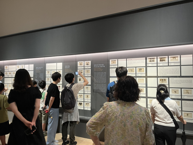 14일 오전 서울 용산구 국립중앙박물관 상설전시관에서 열린 ‘광복 80주년 특별전 다시 찾은 얼굴들’에서 관람객들이 인공지능(AI)으로 복원된 독립운동가 영상을 시청하고 있다. 화면 속에는 안중근 의사가 웃고 있다. 신서희 기자