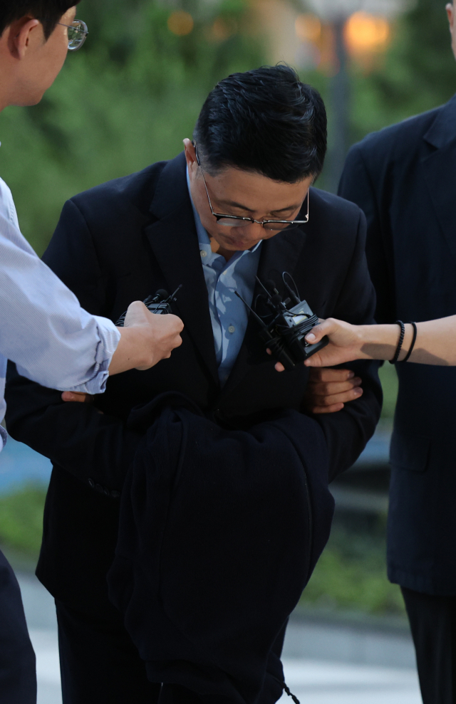 김건희 여사 일가의 '집사'로 지목된 김예성씨가 12일 귀국 직후 인천국제공항에서 체포돼 서울 종로구 김건희특검 사무실로 들어서며 고개 숙여 인사하고 있다. 연합뉴스