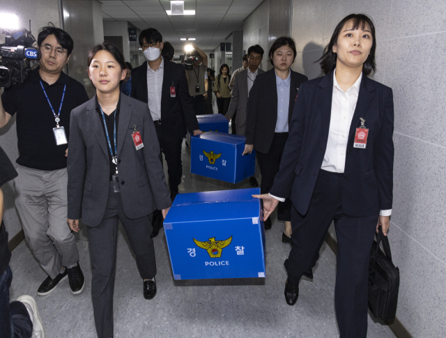 서울경찰청 금융범죄수사대 전담수사팀 관계자들이 11일 주식 차명거래 혐의를 받는 이춘석 의원의 국회 사무실 압수수색을 마친 뒤 압수품을 들고 의원실을 나서고 있다. 연합뉴스