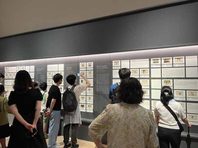 14일 오전 서울 용산구 국립중앙박물관 상설전시관에서 열린 ‘광복 80주년 특별전 다시 찾은 얼굴들’에서 관람객들이 인공지능(AI)으로 복원된 독립운동가 영상을 시청하고 있다. 화면 속에는 안중근 의사가 웃고 있다. 신서희 기자