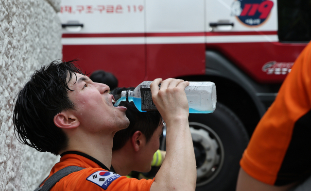 17일 서울 마포구 창전동 한 아파트 화재현장에서 소방대원들이 진화작업 도중 잠시 휴식을 취하고 있다. 연합뉴스
