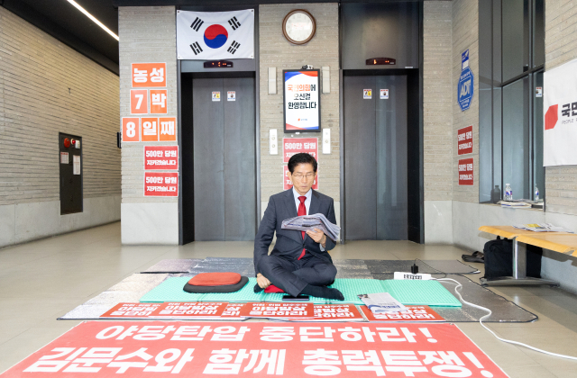특검의 국민의힘 압수수색 저지 농성 중인 김문수 당대표 후보가 20일 서울 여의도 국민의힘 중앙당사 로비에서 신문을 읽고 있다. 뉴스1