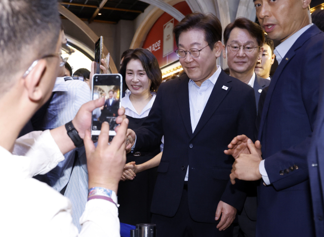 이재명 대통령과 김혜경 여사가 17일 서울 용산CGV에서 '독립군:끝나지 않은 전쟁' 관람 후 시민들과 인사하고 있다. 연합뉴스