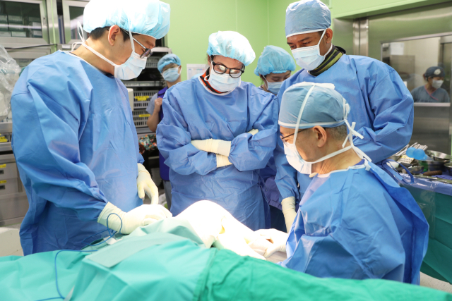 오종건(오른쪽) 고대구로병원 정형외과 교수가 골절 수술을 집도하고 있다. 오 교수의 수술을 배우기 위해 이 병원에서 연수 중인 캐서린 바스(뒷줄 왼쪽) 박사 등이 참관하고 있다. 사진 제공=고대구로병원