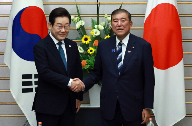 이재명 대통령과 이시바 시게루 일본 총리가 23일 일본 도쿄 총리 관저에서 열린 한일 확대정상회담에 앞서 기념촬영을 하며 악수하고 있다. 연합뉴스