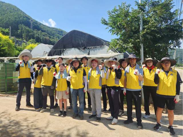 시석중 경기신보 이사장 등 임직원들이 가평 지역 피해 농가에서 복구 작업 후 기념 촬영을 하고 있다. 사진 제공=경기신보