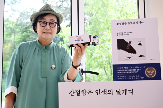 이강미 날개물류 대표가 22일 경기 파주시 은송문학관에서 진행된 서울경제신문과의 인터뷰에 앞서 굿즈로 제작된 트럭모형을 들고 자신의 에세이집을 소개하고 있다. 파주=조태형 기자