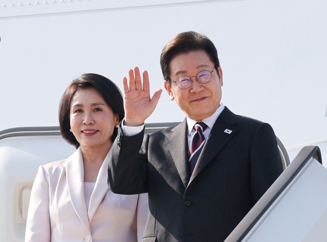 이재명 대통령과 부인 김혜경 여사가 24일 일본 도쿄 하네다공항에서 도널드 트럼프 미국 대통령과의 한미 정상회담을 위해 워싱턴DC로 향하며 공군1호기에 올라 인사하고 있다. 연합뉴스