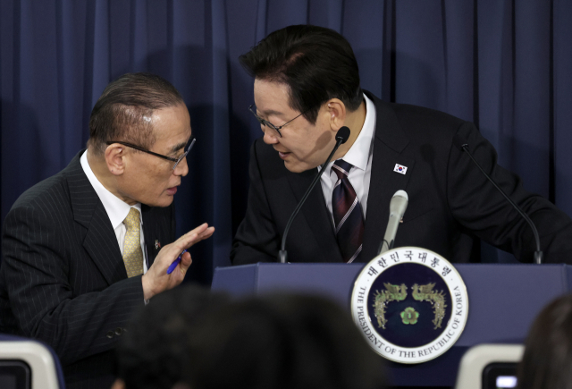 이재명 대통령과 위성락 국가안보실장이 24일(현지시간) 일본 도쿄 하네다공항 이륙 뒤 한미 정상회담을 위해 미국 워싱턴DC로 향하는 공군 1호기 기내에서 기자간담회를 하며 논의하고 있다. 연합뉴스