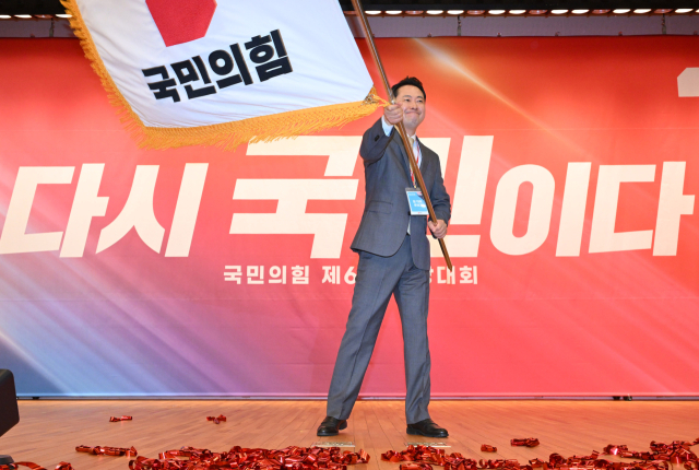 장동혁 국민의힘 신임 당 대표가 26일 서울 여의도 국회도서관에서 열린 제6차 전당대회 결선에서 당기를 흔들고 있다. 오승현 기자
