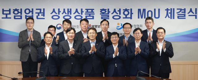 권대영(앞줄 왼쪽 세 번째) 금융위원회 부위원장과 김철주(〃 네 번째) 생명보험협회장 및 이병래(〃 두 번째) 손해보험협회장을 포함한 금융위·보험 업계 인사들이 26일 서울 여의도 보험개발원에서 열린 ‘보험업권 상생상품 활성화 업무협약(MOU)’ 체결식에서 박수를 치고 있다. 사진 제공=금융위