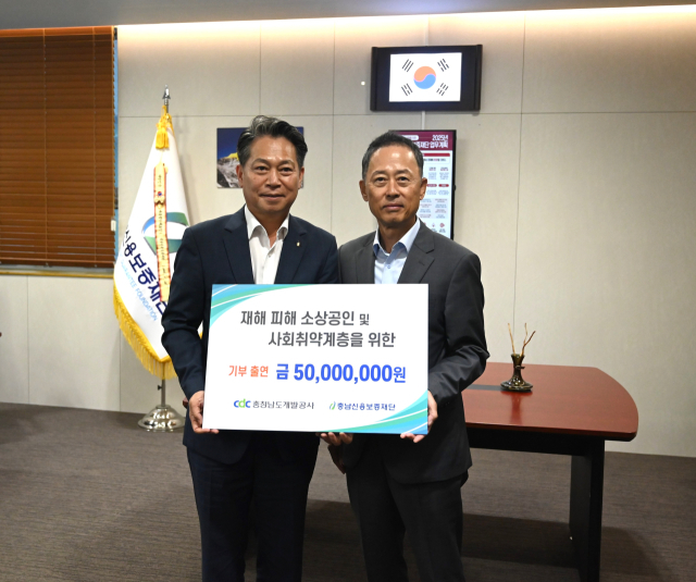 김병근(오른쪽) 충남개발공사 사장이 조소행(왼쪽) 충남신용보증재단 이사장에게 성금 5000만원을 전달하고 기념촬영을 하고 있다. 사진제공=충남개발공사