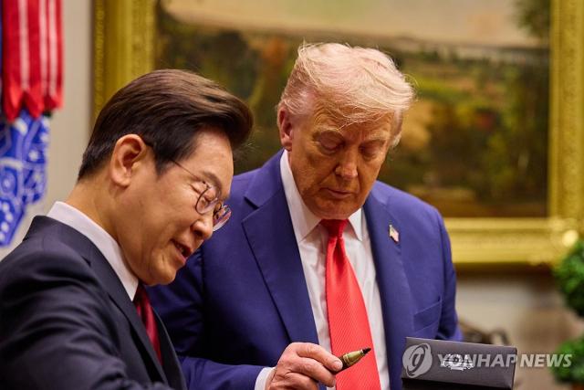 이재명 대통령이 25일(현지시간) 미국 워싱턴DC 백악관에서 열린 한미 정상회담에서 도널드 트럼프 미국 대통령에게 방명록 작성 때 쓴 만년필을 선물하고 있다. 연합뉴스
