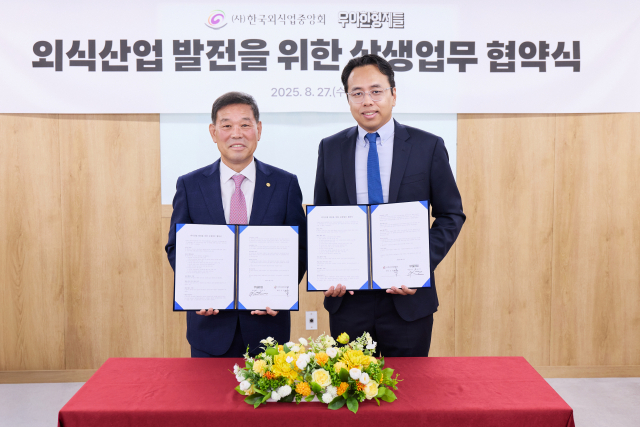 김범석(오른쪽) 우아한형제들 대표이사와 김우석 한국외식업중앙회 회장이 27일 서울 중구 한국외식업중앙회 본사에서 '외식산업 발전을 위한 상생 업무협약'을 체결한 뒤 협약서를 들어보이고 있다. 사진 제공= 우아한형제들