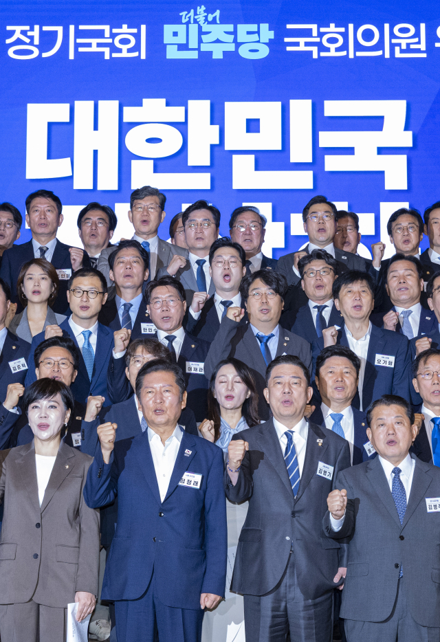 더불어민주당 정청래 대표와 김병기 원내대표를 비롯한 소속 의원들이 29일 인천시 중구 파라다이스시티 컨벤션에서 열린 2025 정기국회 더불어민주당 의원단 워크숍에서 논의해 확정한 결의문을 낭독한 뒤 구호를 제창하고 있다. 연합뉴스