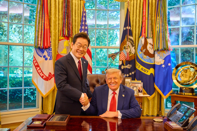 이재명 대통령이 25일(현지시간) 미국 워싱턴DC 백악관 오벌오피스에서 열린 한미 정상회담뒤 도널드 트럼프 미국 대통령과 악수하며 미소짓고 있다. 연합뉴스.