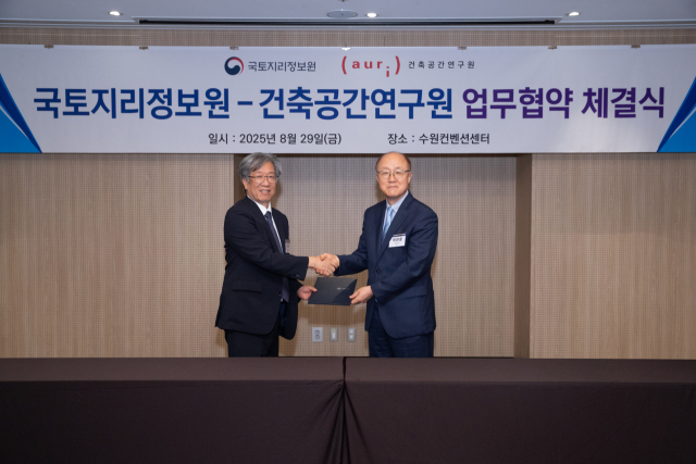 조우석(왼쪽) 국토지리원장과 박환용 건축공간연구원장이 지난 29일 수원컨벤션센터에서 ‘업무협약서’에 서명한 후 악수를 하고 있다. 사진제공=국토지리정보원