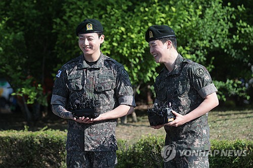 육군 현역 복무를 마치고 만기 전역한 그룹 방탄소년단(BTS)의 지민과 정국이 지난 6월 11일 경기도 연천군 연천공설운동장에서 군복무를 마친 소감을 말하며 환하게 웃고 있다. 연합뉴스