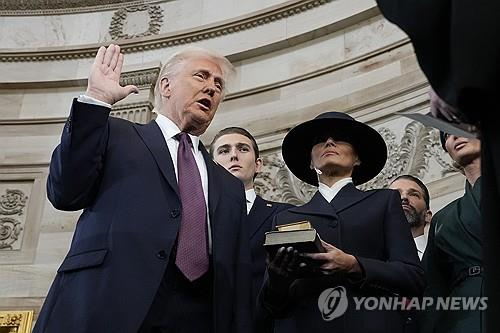 도널드 트럼프 미국 대통령이 부인 멜라니아 여사와 함께 지난 1월 20일(현지 시간) 미 연방의회 의사당 로툰다 홀에서 취임 선서를 하고 있다. 연합뉴스