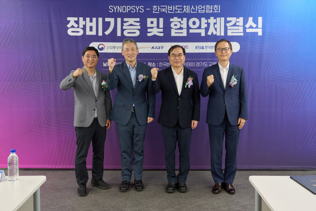 김정회(왼쪽 두번째) 한국 반도체산업협회 상근 부회장 등이 시높시스 에뮬레이터 장비기증 및 협약체결식에 참여해 주먹을 들어 보이고 있다. 사진 제공=한국 반도체산업협회