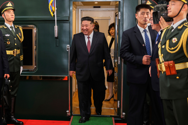 김정은(가운데) 북한 국무위원장이 2일 중국 베이징의 베이징역에 도착해 기차에서 내리고 있다. 김 위원장과 최선희(흰 옷) 외무상 사이에 김 위원장의 딸 주애가 보인다. 신화연합.
