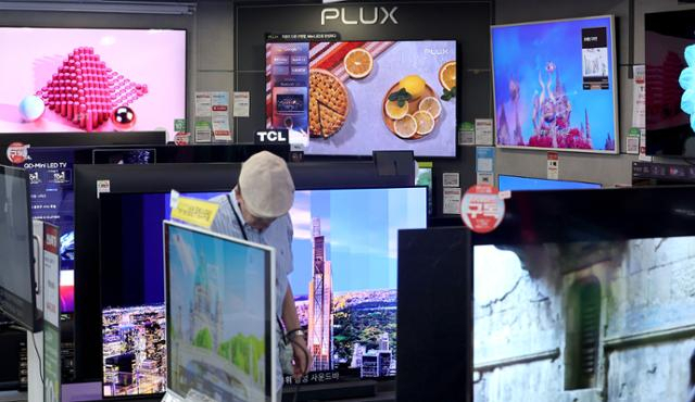 서울의 한 가전제품 매장 방문객이 진열된 TV 제품을 살펴보고 있다. 연합뉴스